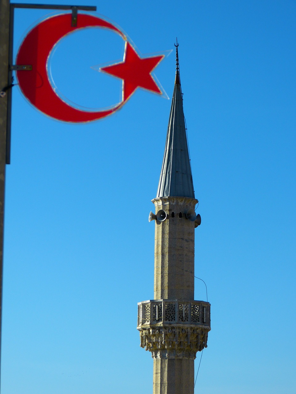 A mosque minaret and star and crescent of the Turkish flag